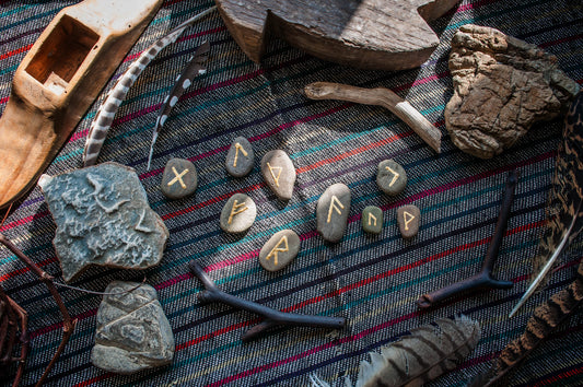 runestones spread out on a colorful blanket with various objects surrounding the stones