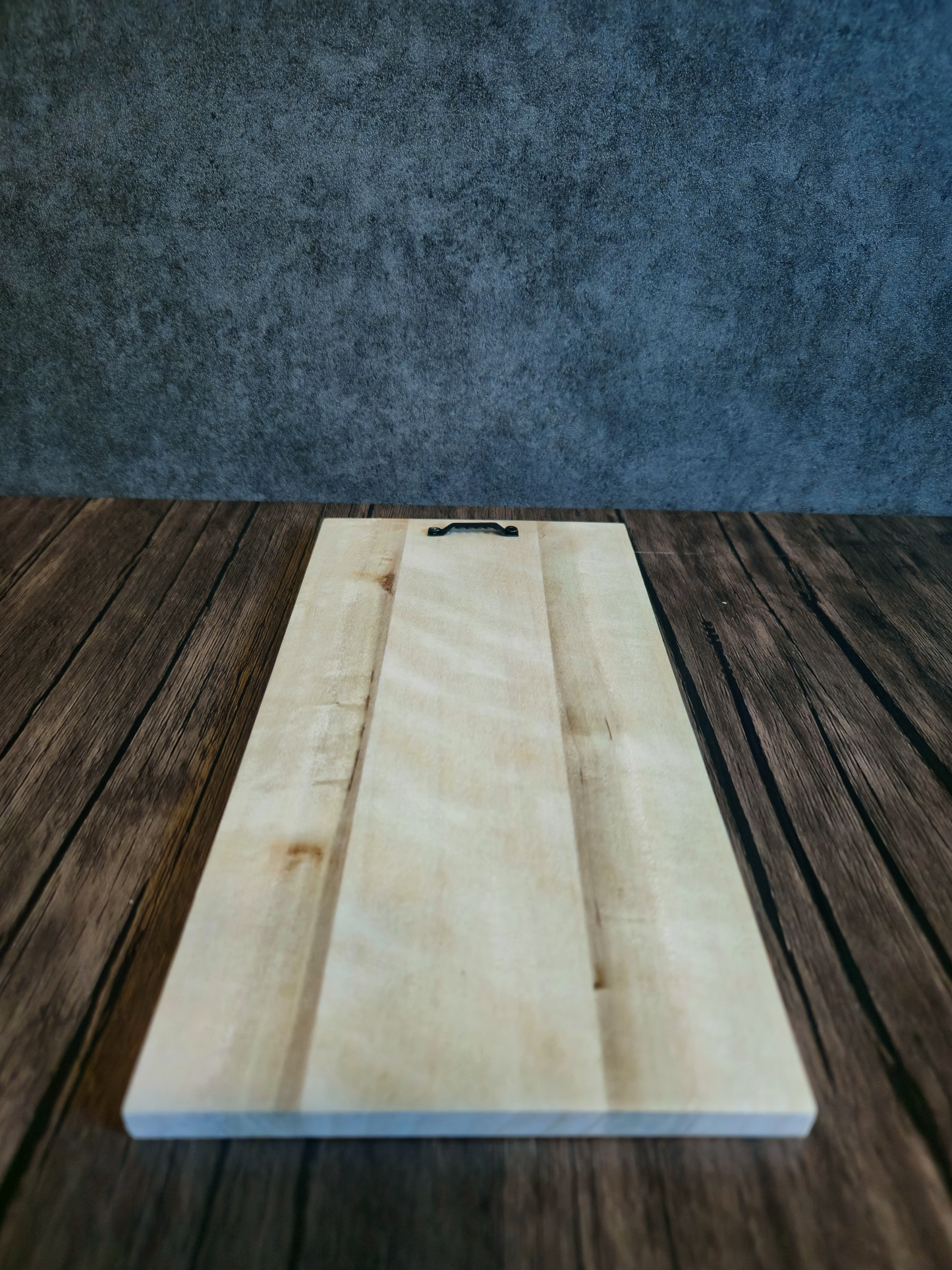 back of artwork showing hanger for hanging Viking artwork with wood pattern, laying on a wooden table with grey background.