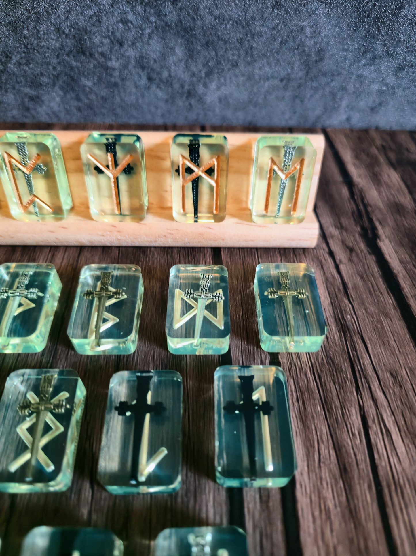 Set of clear resin jewelry pieces with gold and black designs on a wooden stand.
