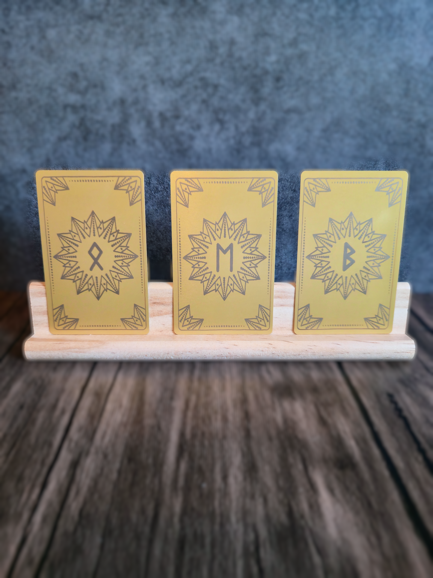 Three yellow cards with star designs on a wooden stand against a dark background