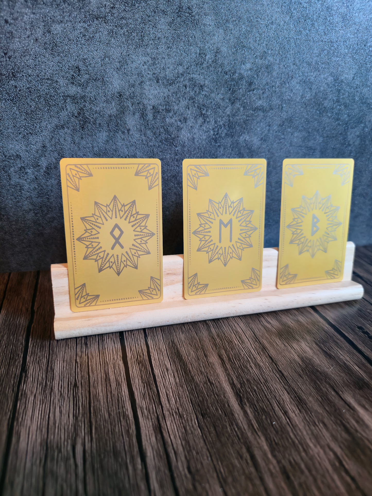 Three yellow cards with star designs on a wooden stand against a dark background
