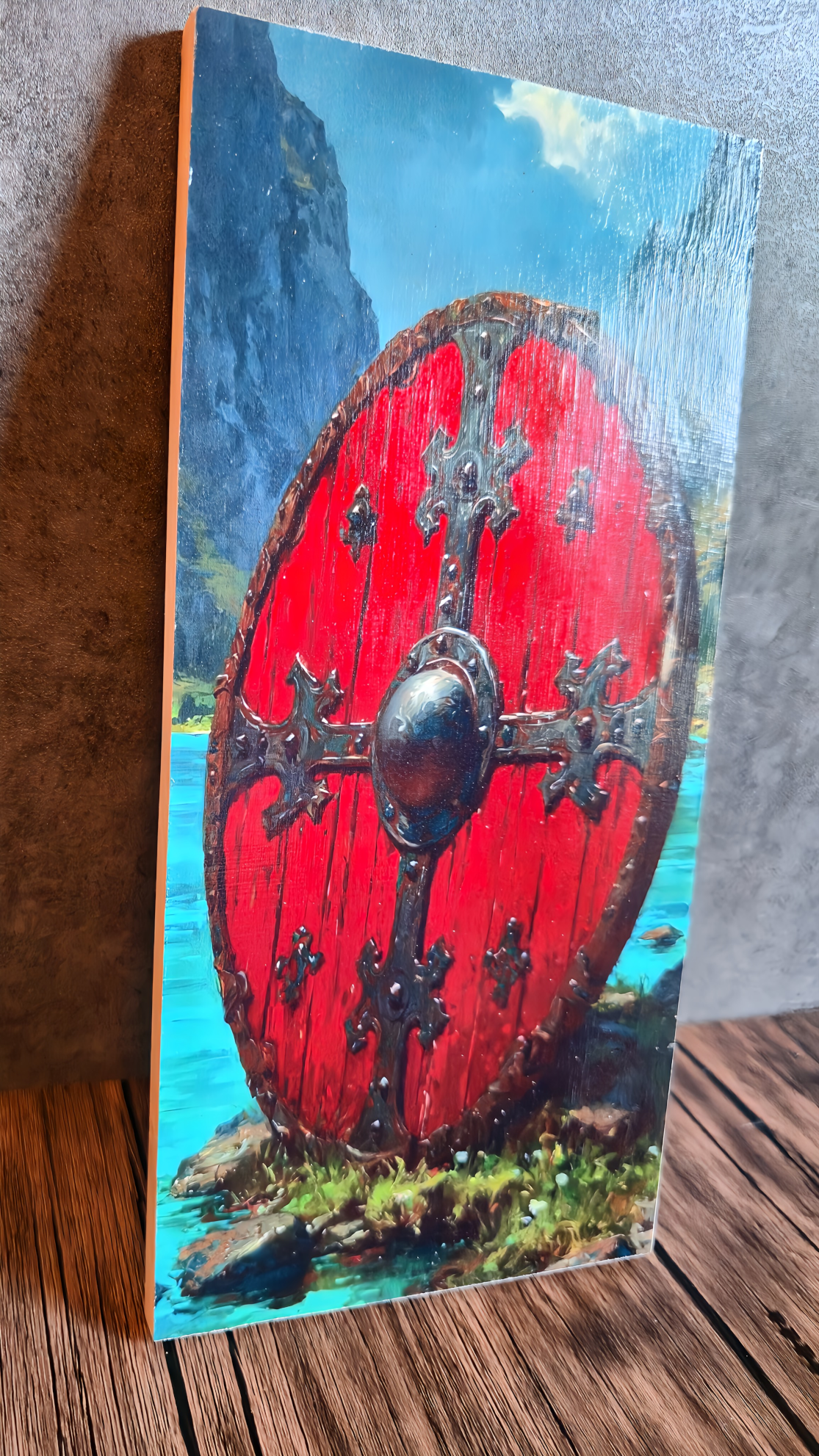 Painting of a red Viking shield with a mountainous landscape in the background