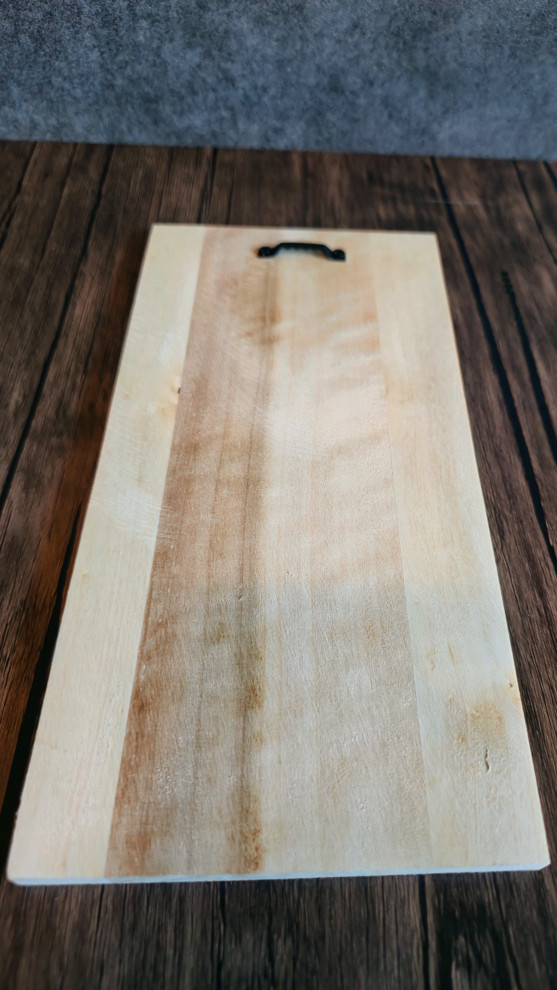 back of artwork that shows wood pattern with hanger on back for hanging artwork.