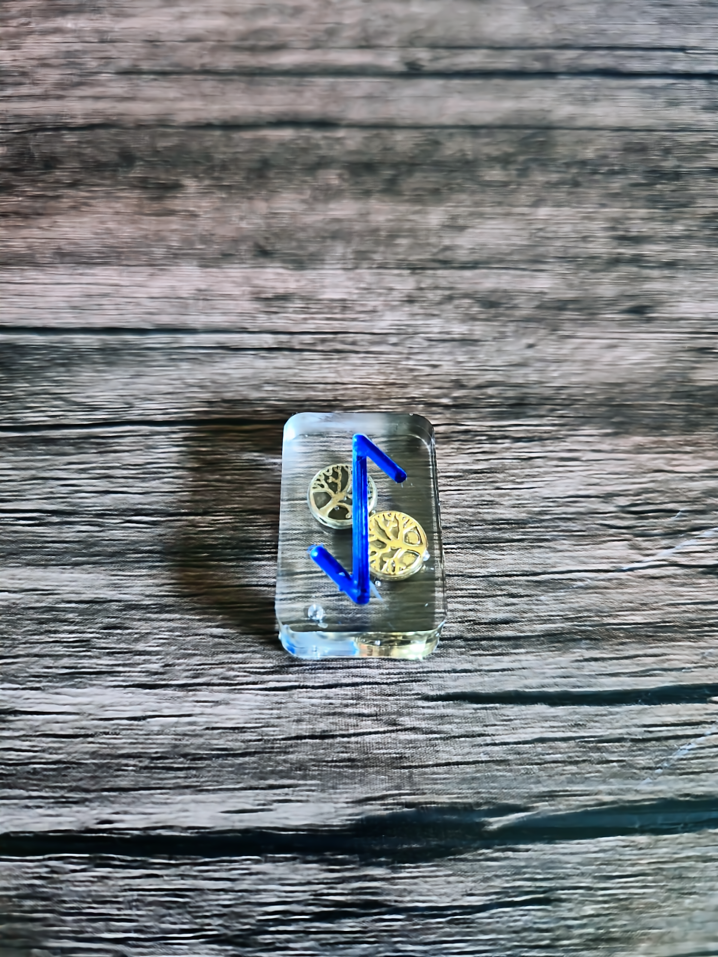 Transparent crystal with blue rune on a wooden surface