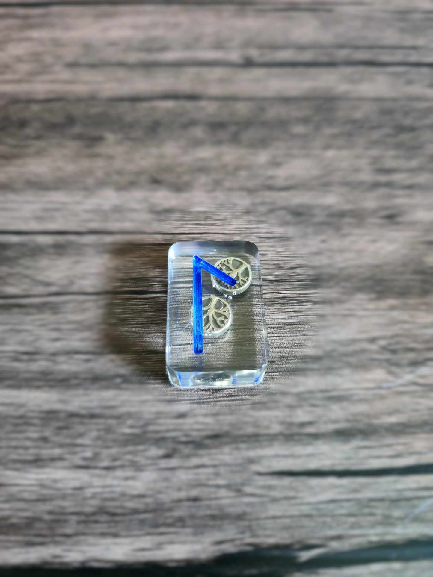 clear runestone with tree of life beads inside on wooden table