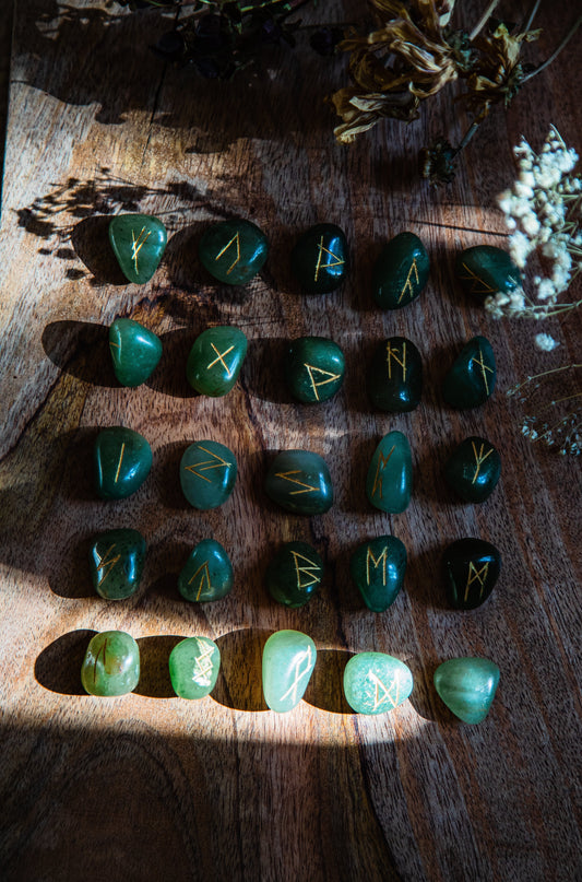 Green rock runestones on wood surrounded by plants