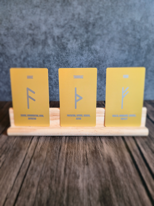 Three yellow cards with symbols on a wooden stand against a blue textured background