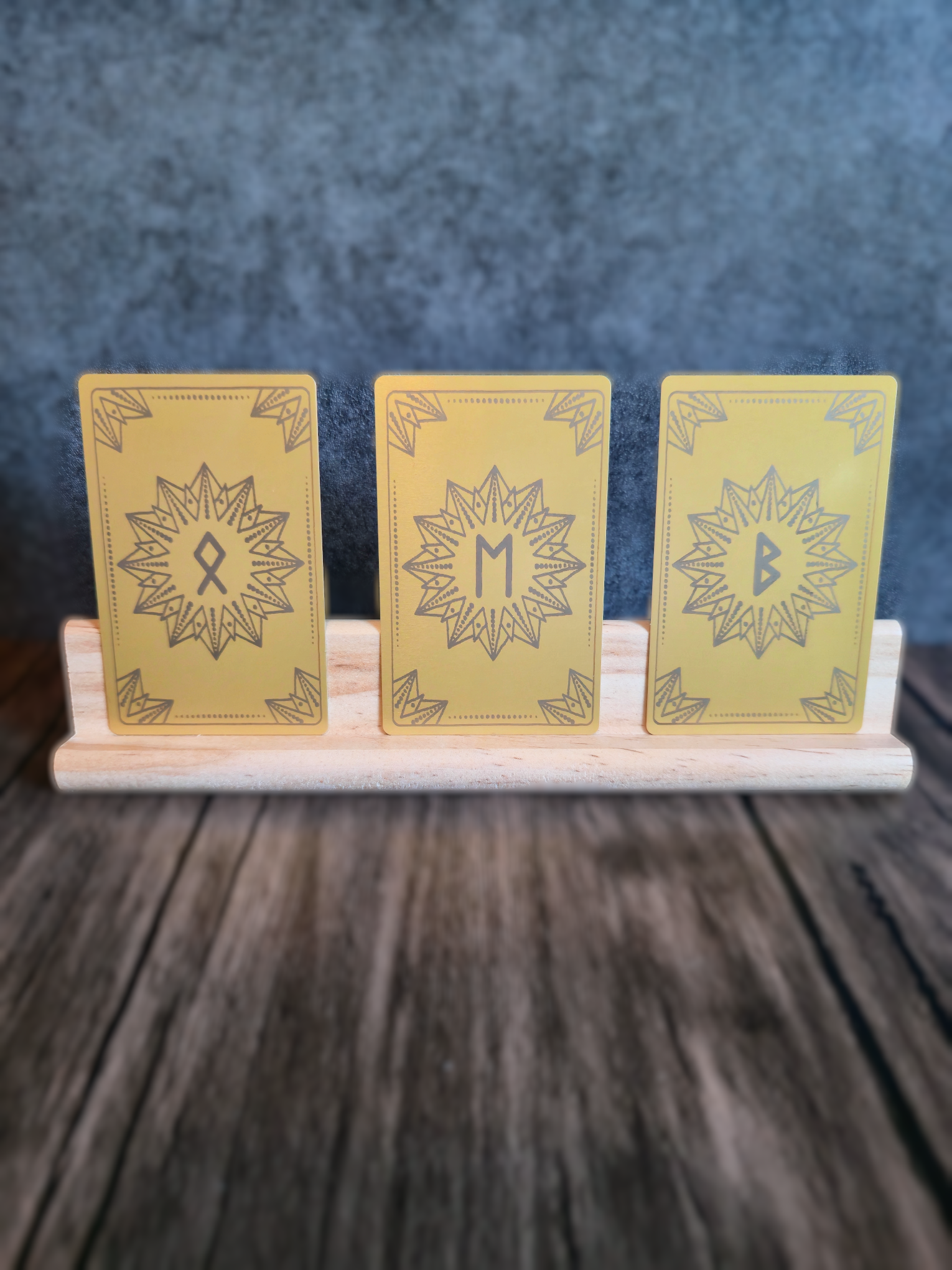 Three yellow cards with star designs on a wooden stand against a dark background