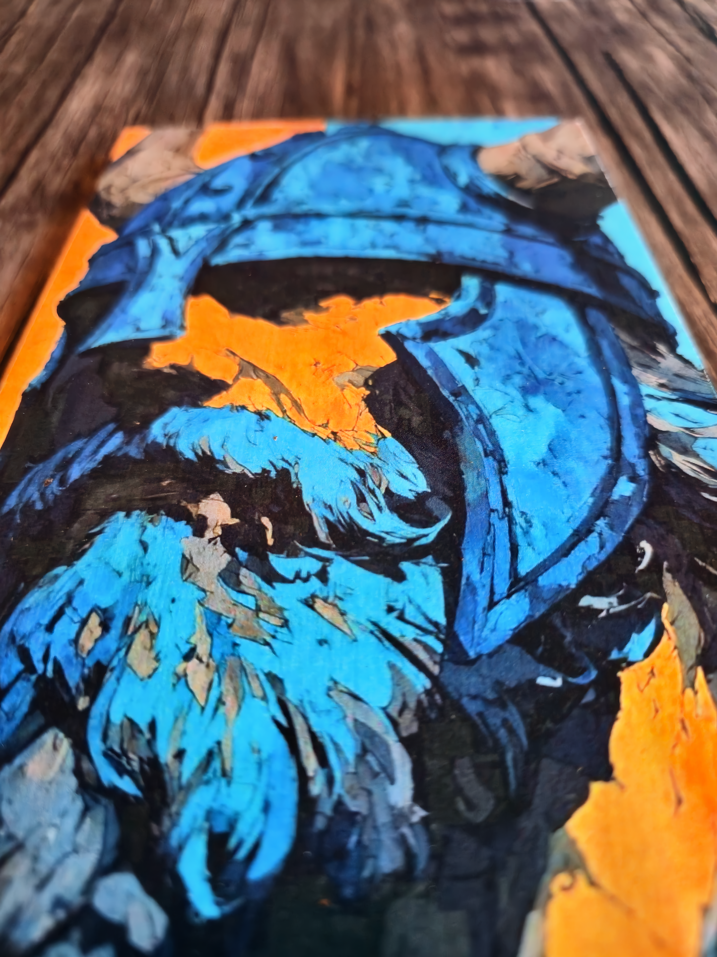 Abstract art piece with blue and orange colors on a wooden surface