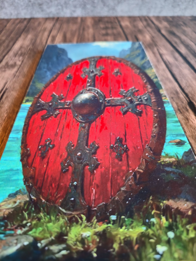 Red roundel with metal cross designs on a scenic background