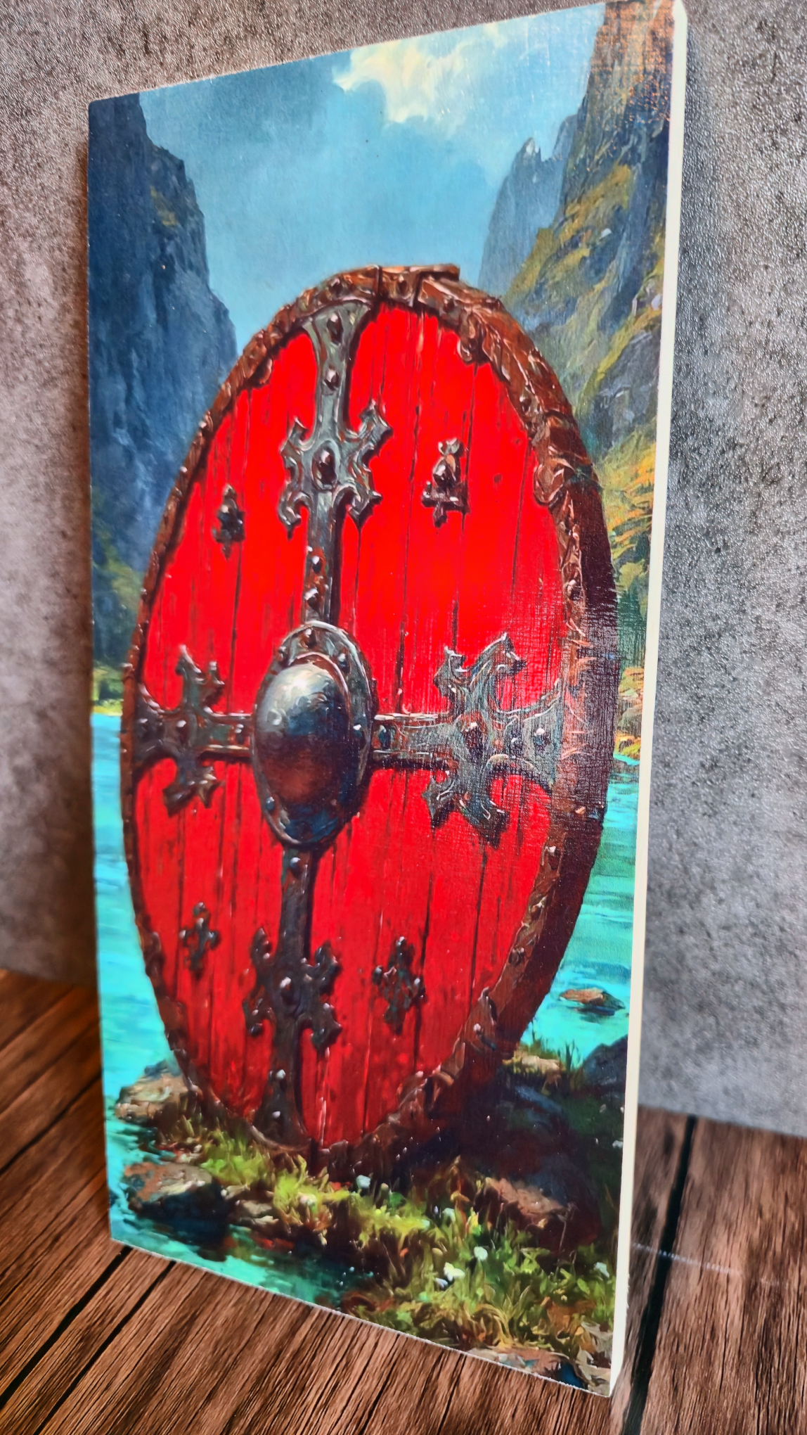 Red shield with silver cross patterns against a mountainous landscape